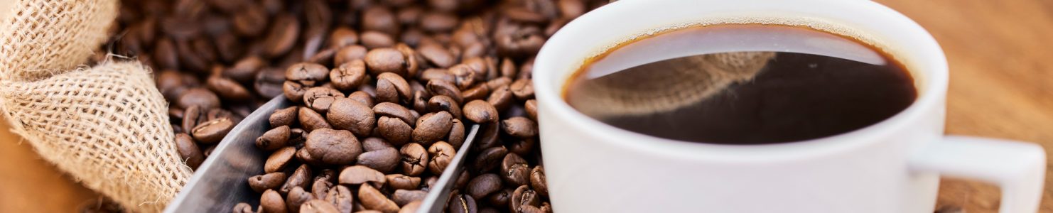 loose coffee beans and brewed coffee in a cup